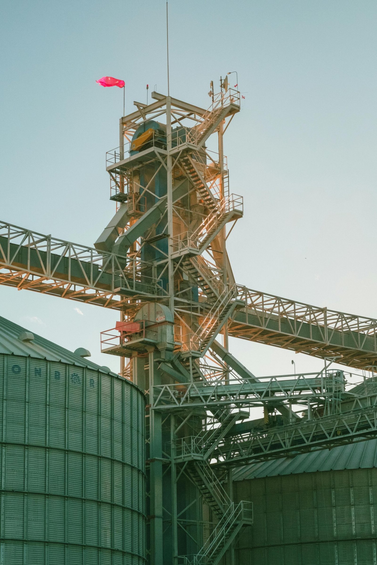 A towering industrial structure with metal walkways against a clear sky backdrop.
