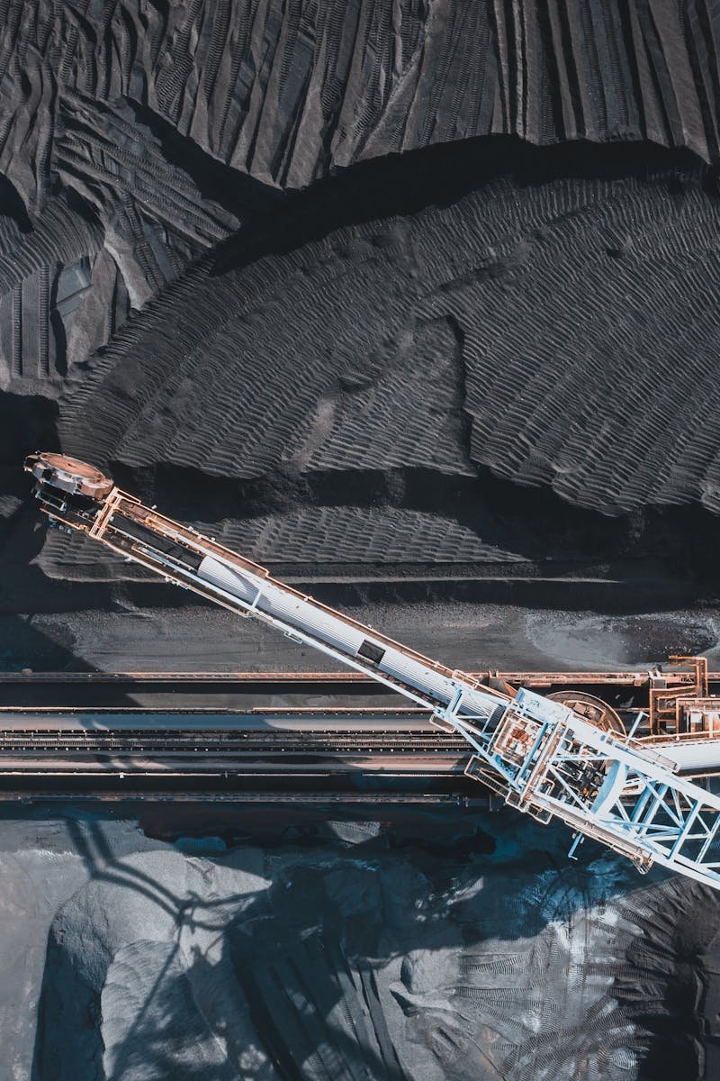 Top view of modern industrial machinery working with black natural coal in daylight